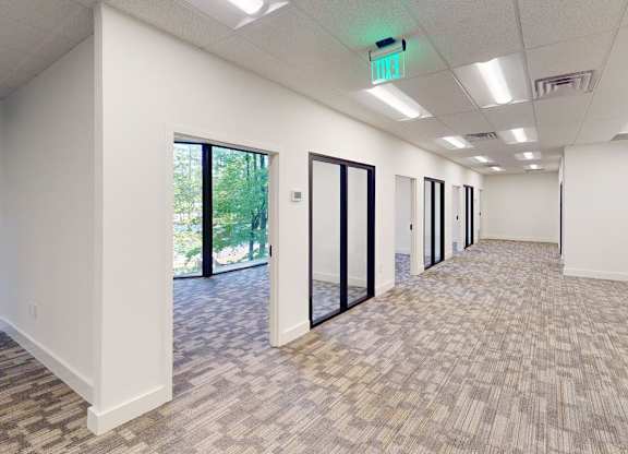 A long hallway with carpeted floors and white walls.