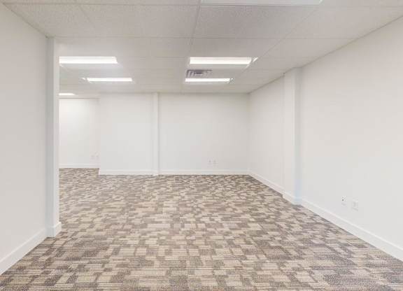 A room with a carpeted floor and white walls.