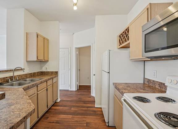 A kitchen with white appliances and wooden cabinets