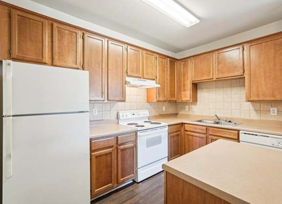A kitchen with wooden cabinets and white appliances.