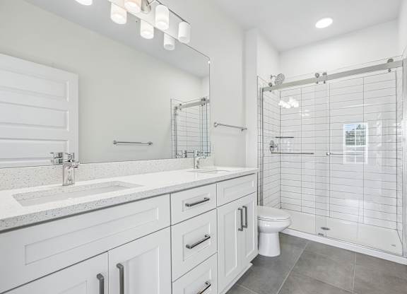 Bathrooms with glass door stand-up showers and double vanity sink