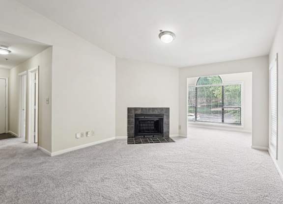 A spacious living room with a fireplace and a sun room