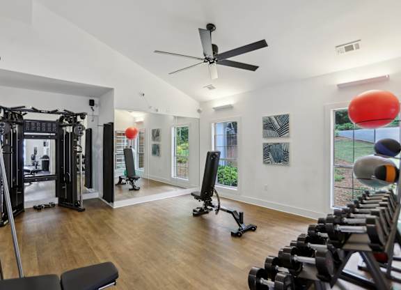 A gym with a variety of equipment including weights and a treadmill.