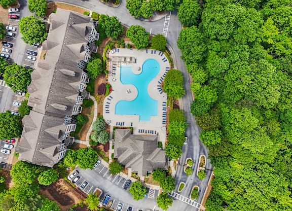 An aerial view of a swimming pool surrounded by trees.