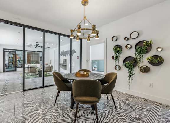A dining room with a table and chairs and a chandelier.