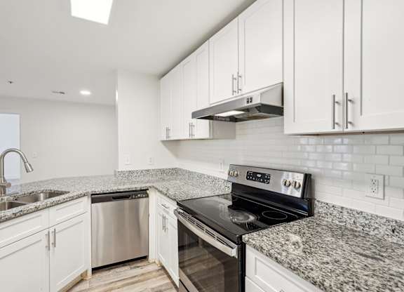 A modern kitchen with granite countertops and stainless steel appliances.