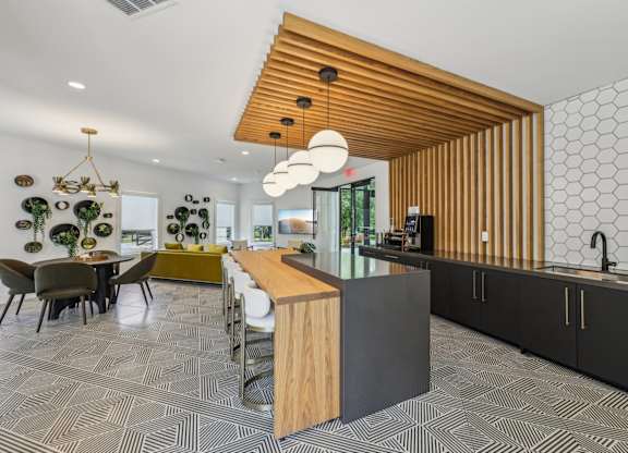 A modern kitchen with a wooden ceiling and a patterned floor.
