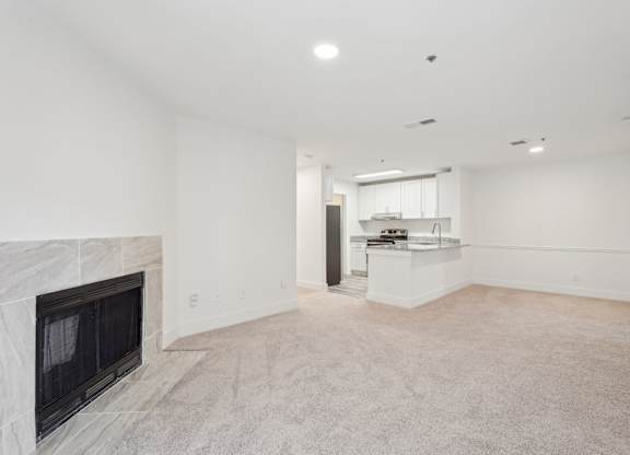 A large living room with fireplace and dining room with view of kitchen