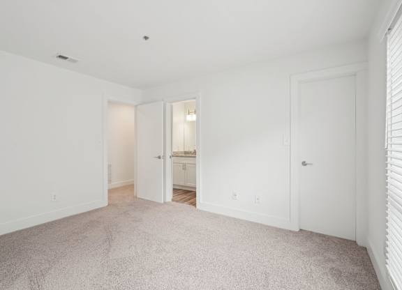 A white room with a carpeted floor and two doors.