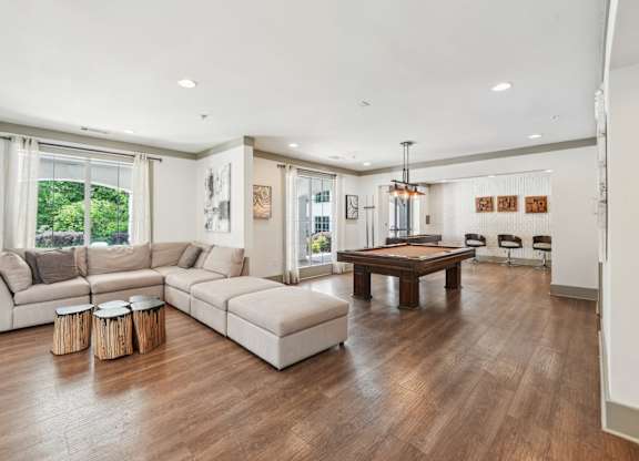 Resident clubhouse with couch, billiards, shuffle board and seating
