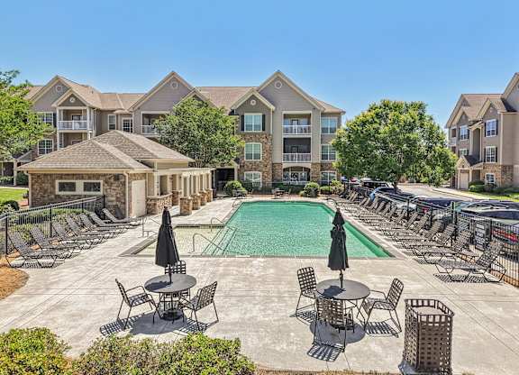 pool with lounge chairs and tables with umbrellas