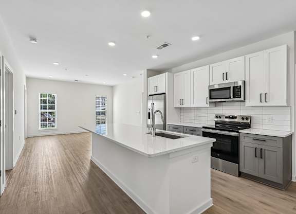 A modern kitchen with white cabinets and a large island.