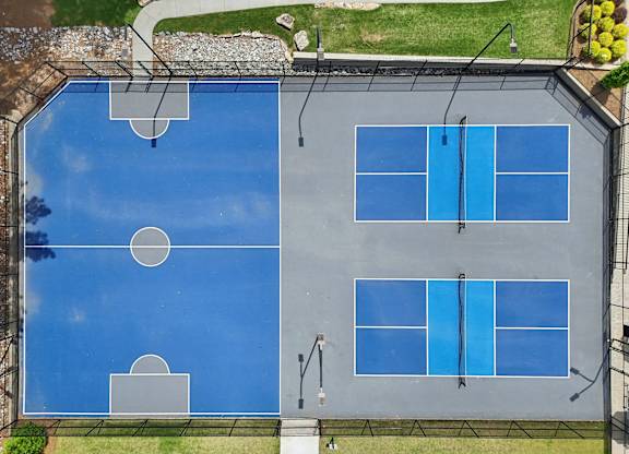 A tennis court with blue surface and white lines.