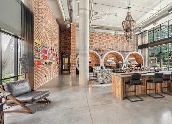 Resident clubhouse with bar seating, wine fridge, many seating areas with couches, work booths, and chairs