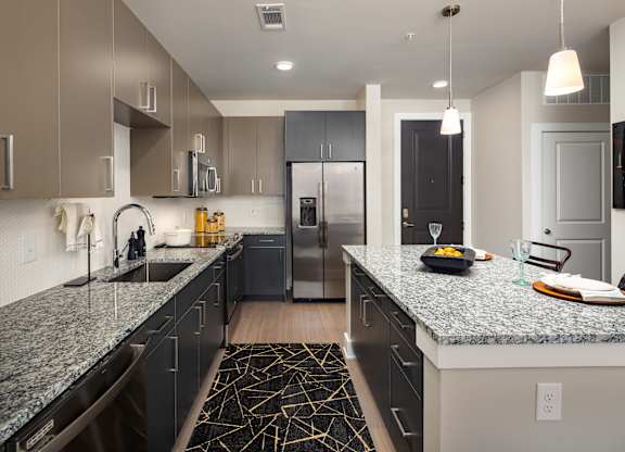 A modern kitchen with granite countertops and stainless steel appliances.