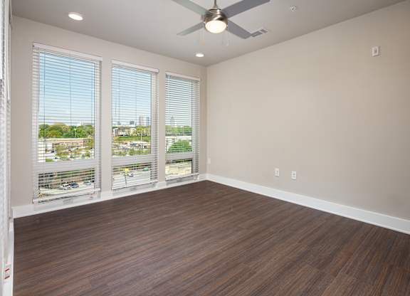 A bedroom with a ceiling fan and  floor-to-ceiling windows