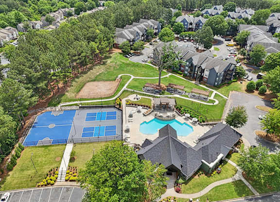A bird's eye view of a residential area with a swimming pool and tennis court.