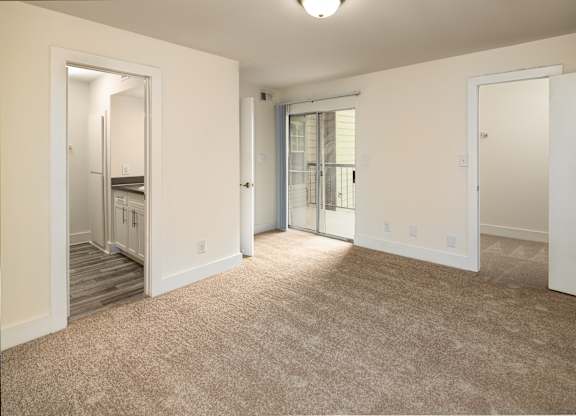 A bedroom with a carpeted floor and a staircase leading to another room.