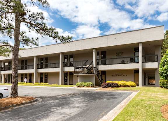 A large white building with a balcony on the second floor.