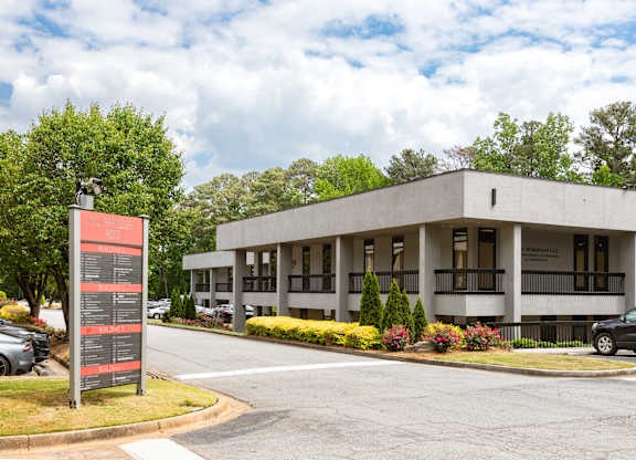 A modern building with a parking lot in front.