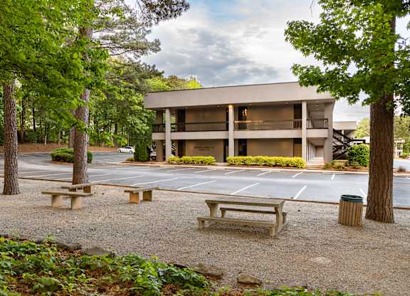 A modern building with a parking lot in front.