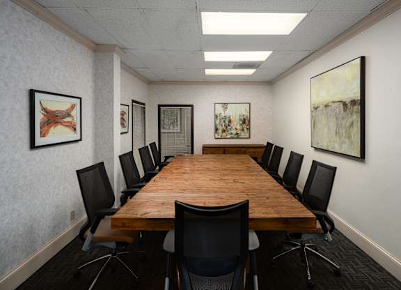 A conference room with a long table and chairs.