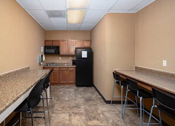 A kitchen with a black refrigerator, microwave, and oven.