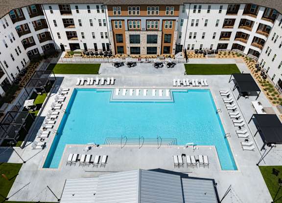 A large swimming pool surrounded by apartment buildings. the largest pool in douglasville georgia.