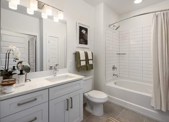 A white bathroom with a toilet, sink, and bathtub.