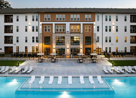 A large building with a pool in front of it.