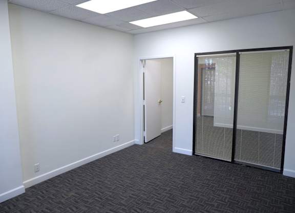 A room with a carpeted floor and a glass door.