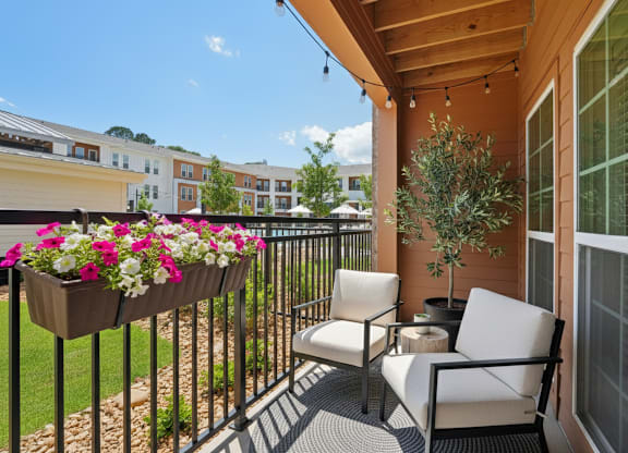 A patio with a chair and a table with a potted plant on it.