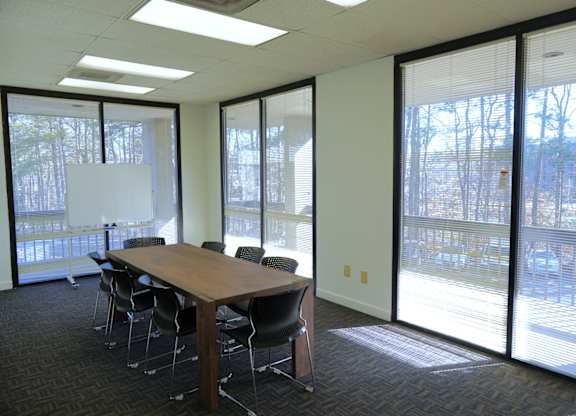 A conference room with a long table and chairs.