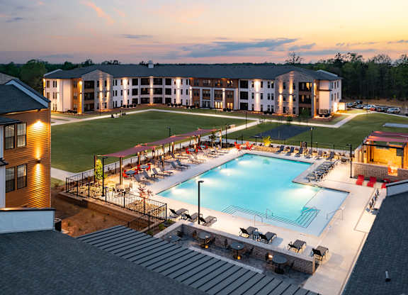 A large building with a pool in front of it.