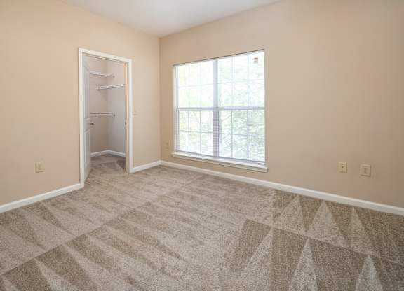 A room with a carpeted floor and a large window.