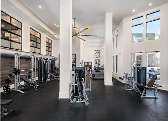 A gym with a variety of equipment and a large mirror on the wall.