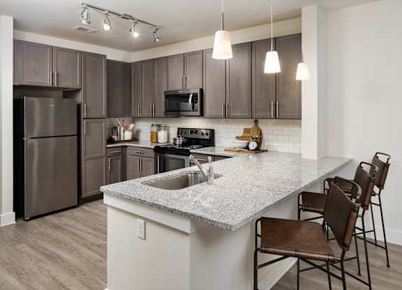 A modern kitchen with wooden cabinets and a granite countertops