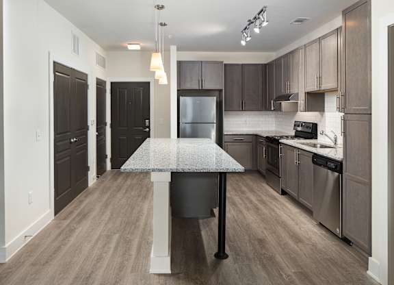 A kitchen with a table and chairs in the middle of it.