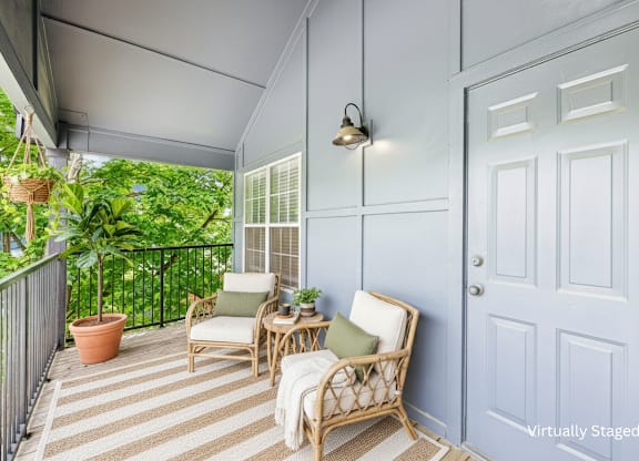 A patio with a white door and a striped rug.
