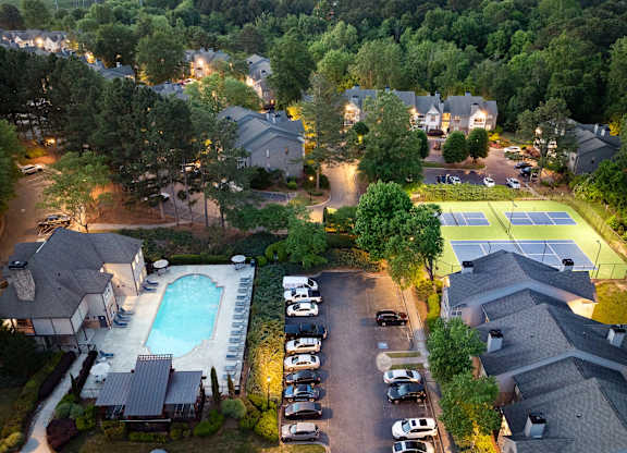 A residential area with houses, a swimming pool, and tennis courts.