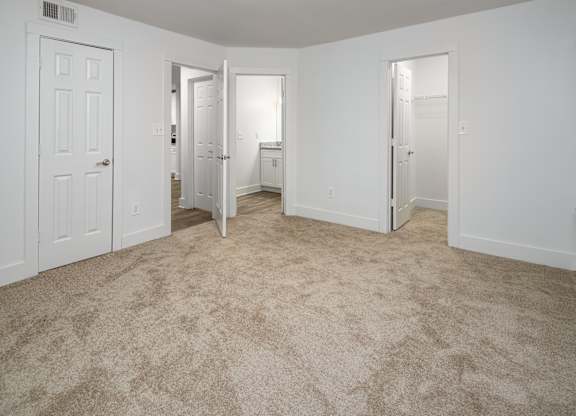 A bedroom with carpeted floor, bathroom and walk-in closet