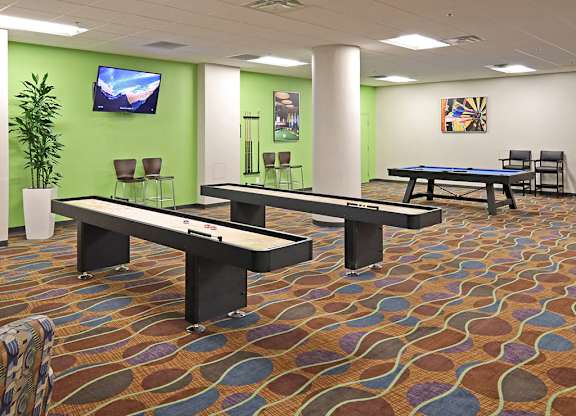 A room with a pool table and a TV on the wall.
