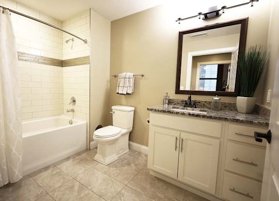 A bathroom with a toilet, sink, and tub.