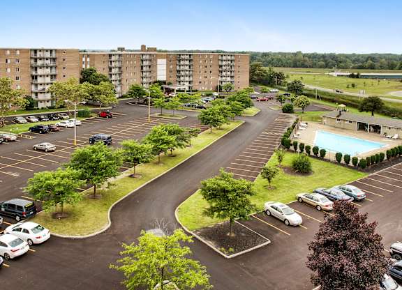 A parking lot with cars and apartment buildings in the background.