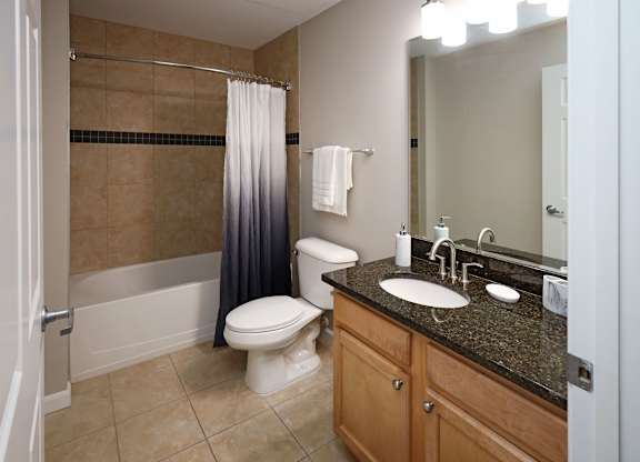 A bathroom with a toilet, sink, and shower.