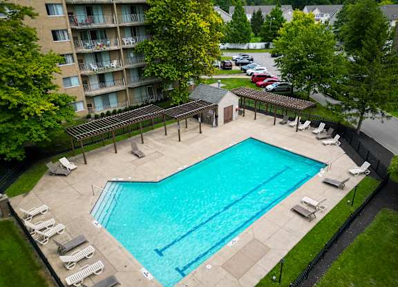 outdoor swimming pool and sundeck surrounded by trees at Willoughby Hills Towers Apartments, Willoughby Hills, OH 44092