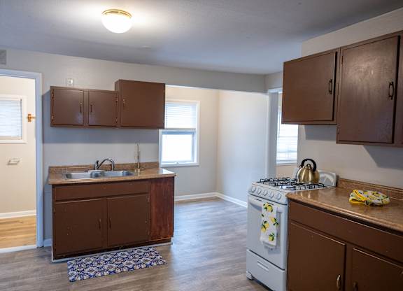A kitchen with a white stove and brown cabinets.
