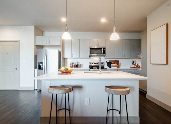a kitchen with two stools in front of a counter top at Parkside at Littleton Village, Littleton