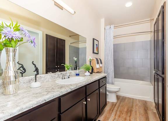A bathroom with a marble countertop and a toilet in the corner.