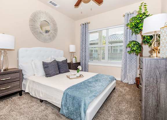 A bedroom with a white bed and a blue blanket.